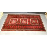 A North West Persian Woollen Rug with an all design upon a red, cream and blue ground within