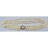 A Cultured Pearl Three Strand Necklace, with yellow metal pearl and diamond set clasp, 46cms long