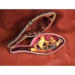 Meerschaum Pipe with a Cherub spearing a bug through a bush, in its box. The amber stem is still