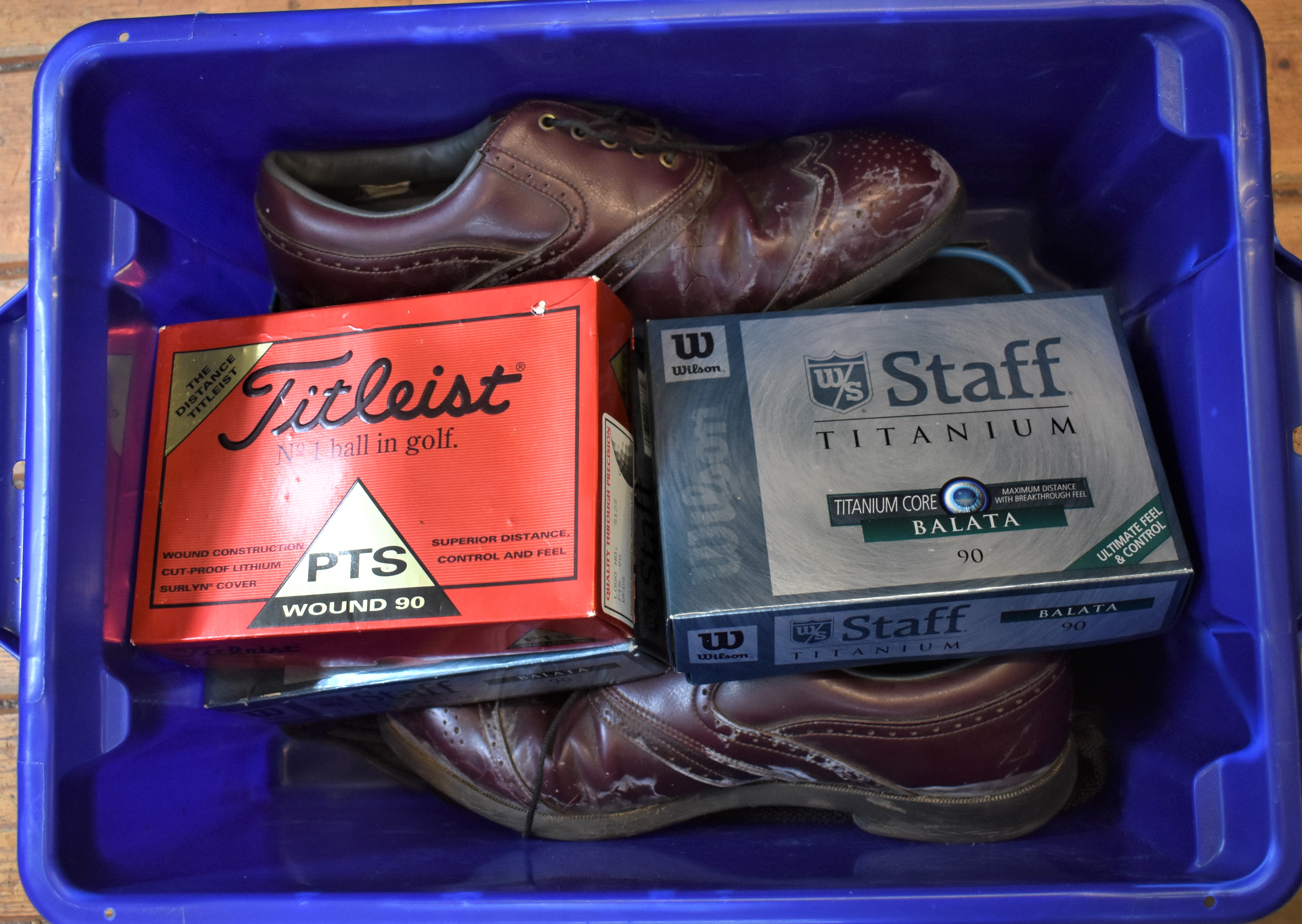 Box filled with balls new in boxes. Golf T's, mix of used and new. Two pairs of used shoes