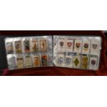 Military Cigarette cards in plastics as an album. Sets, partial sets, and some rare cards.