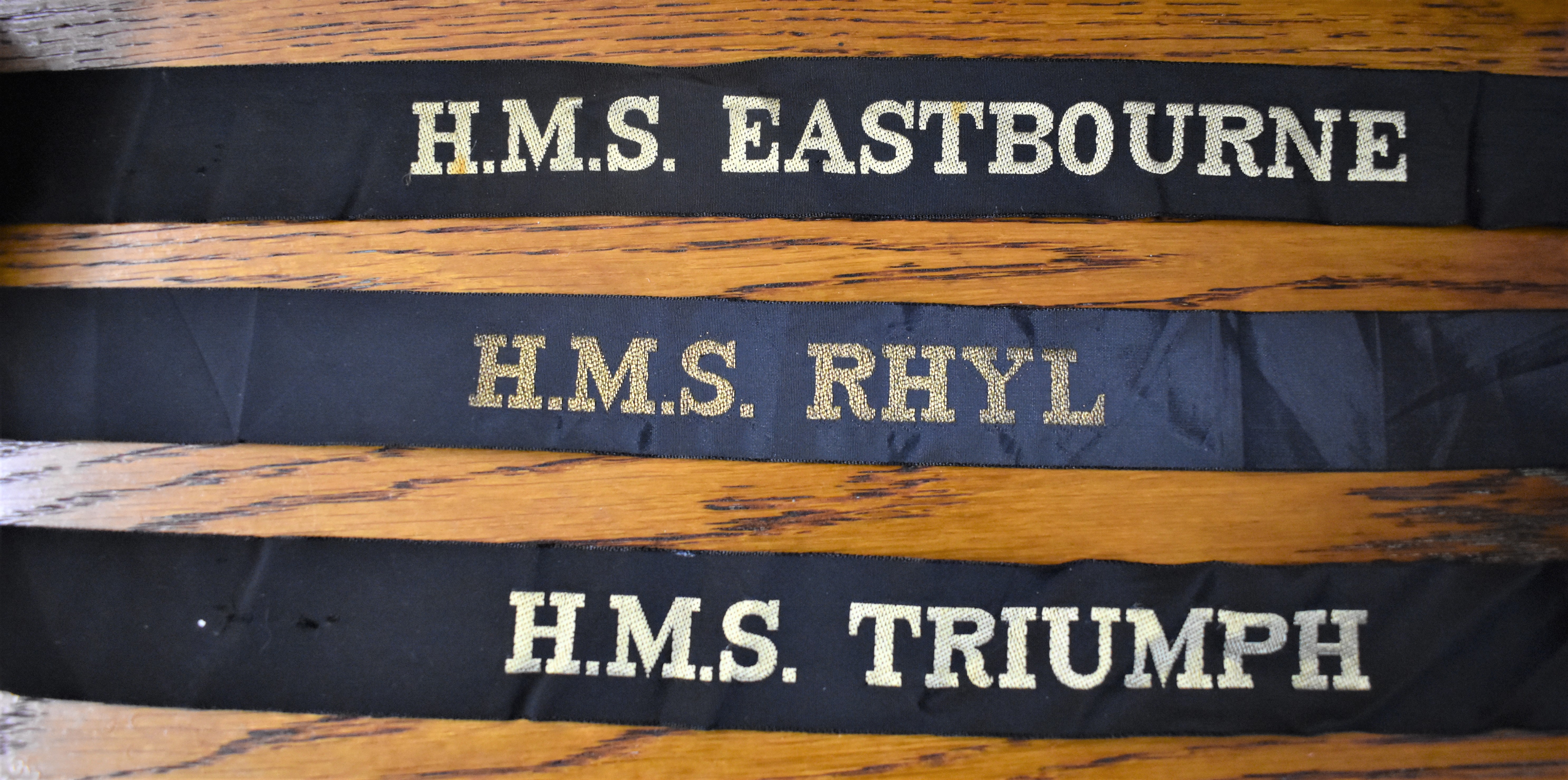 British Naval Cap Tallies (3):- H.M.S. RHYL, H.M.S. TRIUMPH and H.M.S. EASTBOURNE:- H.M.S. Rhyl