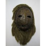 ETHNIC MASK, a carved Tortoiseshell ethnic mask with rope fringe surround, possibly Ivory Coast, 7.