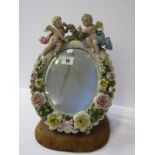 THURINGIAN MIRROR, cherub crested floral encrusted oval easel mirror on early velvet stand, 11.5"