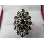 18ct WHITE GOLD SAPPHIRE & DIAMOND CLUSTER RING, principal dark blue sapphire surrounded by halo