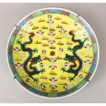 A 19TH CENTURY CHINESE FAMILLE JAUNE / ROSE DRAGON DISH, the yellow ground decorated with scenes