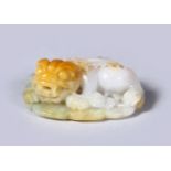 AN 18TH / 19TH CENTURY CHINESE CARVED WHITE JADE PENDANT OF A LION DOG, the dog in a seated