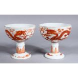 A PAIR OF LATE QING DYNASTY CHINESE IRON RED PORCELAIN DRAGON STEM CUPS, the body of the cups