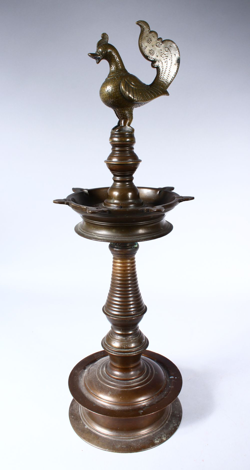 A GOOD 19TH CENTURY INDIAN BRONZE LAMP, with cockerel finial on a circular base, 60cm high.