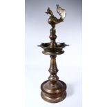 A GOOD 19TH CENTURY INDIAN BRONZE LAMP, with cockerel finial on a circular base, 60cm high.