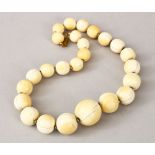 A SET OF 19TH CENTURY CARVED IVORY BEAD NECKLACE, comprising of 25 graduating size round beads, with