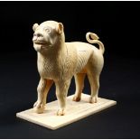 A GOOD EARLY CARVED IVORY MODEL OF A STANDING MALE LION, on a rectangular base, 13cm long.