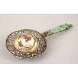 A 19TH CENTURY CHINESE JADITE AND SOLID SILVER TEA STRAINER, the jadeite carved in lotus style,