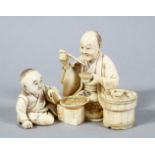 A GOOD JAPANESE MEIJI PERIOD CARVED IVORY OKIMONO OF MAN & BOY, both seated eating food from the