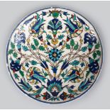 A 19TH CENTURY TURKISH OTTOMAN KUTAHIYA CIRCULAR POTTERY DISH, with Iznik style floral decoration,