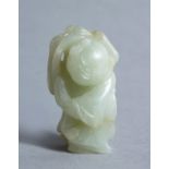 A GOOD CHINESE POSSIBLY 16TH / 17TH CENTURY CELADON JADE CARVING OF A BOY, the boy bearing a grin