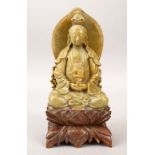 A 20TH CENTURY CHINESE CARVED SOAPSTONE FIGURE OF GUANYIN, in a seated position holding a vase and