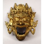A 19TH CENTURY OR EARLIER CHINESE BRONZE FIGURE OF A MASK, the mythical face with its mouth open,
