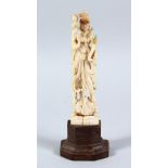 A 19TH CENTURY INDIAN CARVED IVORY FIGURE OF DEITY / BUDDHA, fitted to a hardwood base, 19cm high.