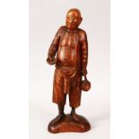 A 19TH / 20TH CENTURY CHINESE BOXWOOD CARVED FIGURE OF A MAN, the man holding a teapot in one hand