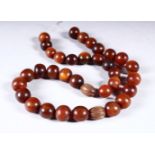 A BEAD NECKLACE, rhino horn, comprising 35 beads, approx. 15mm diameter and smaller, weight