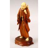 A JAPANESE MEIJI PERIOD CARVED WOOD & IVORY OKIMONO OF A MAN, the man stood with a double ourd