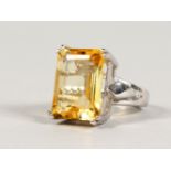 A SILVER AND LARGE EMERALD CUT CITRINE RING.