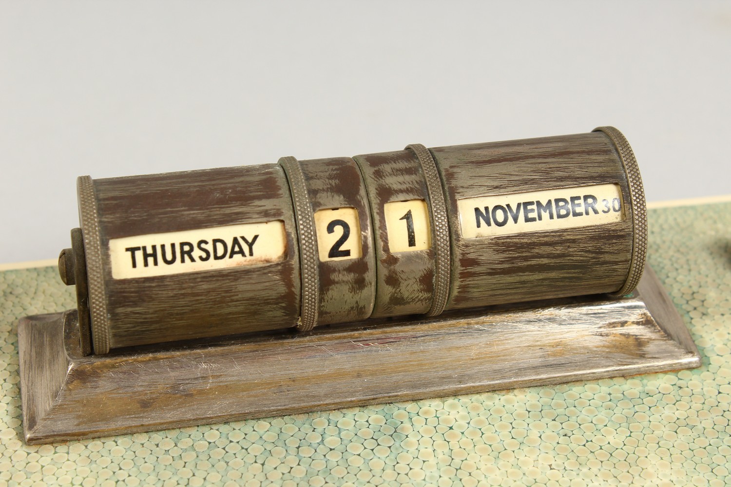 A SHAGREEN DESK STAND, EARLY 20TH CENTURY, mounted with a plated perpetual calendar. 10ins long x - Image 2 of 3