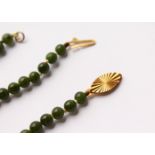 A JADE BEAD NECKLACE AND BRACELET, with 9ct gold clasps. Necklace 16.5ins long, bracelet 7ins long.