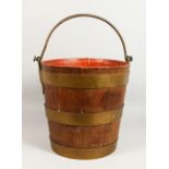 A BRASS BANDED OAK BUCKET with handle. 14ins high.
