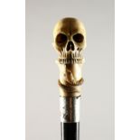 A CARVED IVORY SKULL WALKING STICK with silver band. 2ft 8ins long.