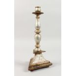 A SILVERED TURNED WOOD CANDLESTICK, on a triangular base. 13.5ins high.