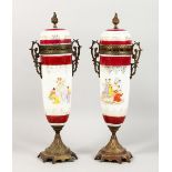 A PAIR OF FRENCH METAL AND PORCELAIN URNS AND COVERS, decorated with classical scenes. 17ins high.