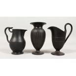 TWO WEDGWOOD BLACK BASALT MILK JUGS and A VASE, 5ins (2) and 4.5ins high, all impressed WEDGWOOD.