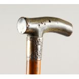 A CARVED RHINO HANDLE WALKING CANE with silver band. 2ft 11ins long.