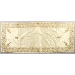 A SILK TABLE RUNNER, decorated to the border with gold and silver thread. 50ins x 20ins.