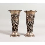 A PAIR OF PIERCED STERLING SILVER VASES 5.5ins high.