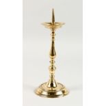 A BRASS PRICKET CANDLESTICK, on a circular base. 11.5ins high.