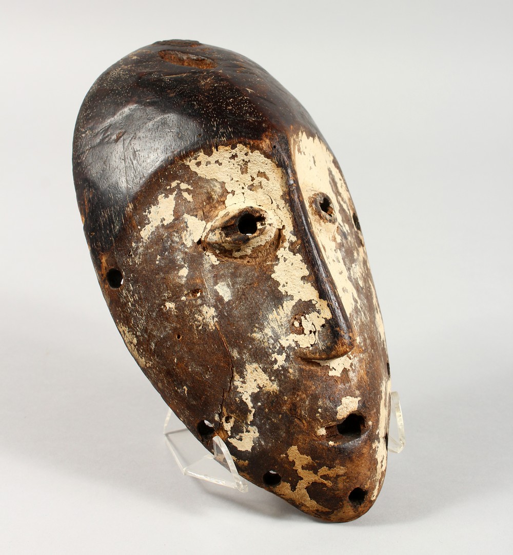 A CARVED AND PAINTED WOOD TRIBAL MASK. 9.5ins high.
