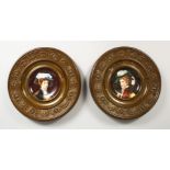 A PAIR OF EMBOSSED CIRCULAR BRASS PLAQUES, inset with porcelain panel decorated with portrait busts.