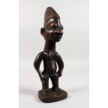 AN YORUBA TRIBE CARVED WOOD STANDING FEMALE FIGURE, with traces of original pigment. 11ins high.
