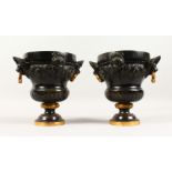 A GOOD PAIR OF 19TH CENTURY GILDED AND BRONZE URNS, with shell and lion handles and masks. 8ins
