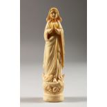 AN EARLY CARVED IVORY FIGURE OF A WOMAN PRAYING. 6ins high.