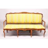 AN 18TH CENTURY STYLE CONTINENTAL WALNUT FRAMED SETTEE, with shaped top rail, over-stuffed back
