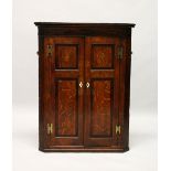 A 19TH CENTURY OAK AND MAHOGANY HANGING CORNER CUPBOARD, with two panelled doors. 3ft 6ins high x