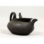 A WEDGWOOD BLACK BASALT OVAL TEAPOT AND COVER, with female knop handle, the sides with cupids.