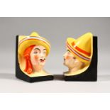 A PAIR OF COLOURFUL ART DECO POTTERY BOOK ENDS modelled as Mexican busts. 5ins high.