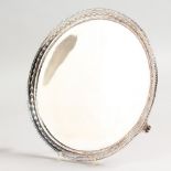 A VICTORIAN CIRCULAR SALVER, with bead and harebell border, on three curving legs. 25cm diameter.