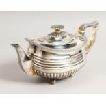 A GEORGE III SEMI FLUTED TEAPOT, gadrooned edge, on ball feet. London 1814. Weight 19ozs.