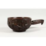 AN UNUSUAL CARVED WOOD BOWL, the handle as a dragon, the bowl carved with dragons and leaves.